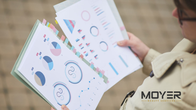 Person reviewing housing market charts and graphs – Tucson real estate monthly report