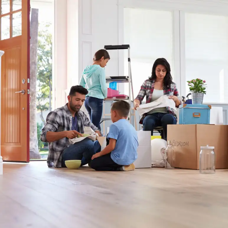 Family unpacking boxes in new Tucson home, representing planning ahead in the home buying process